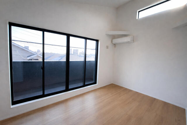 リビング以外の居室／主寝室（洋室約８．２帖）。勾配天井・大型窓・エアコン付きで開