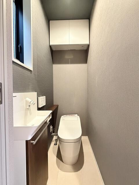 トイレ／タンクレストイレで手洗いもあります。上部には収納棚もあります