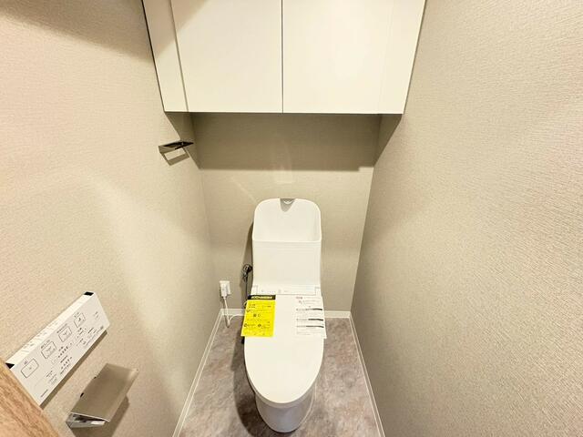 トイレ／温水洗浄便座付きの清潔感あるトイレ空間。上部には吊戸棚収納を／撮影日2026-02-04