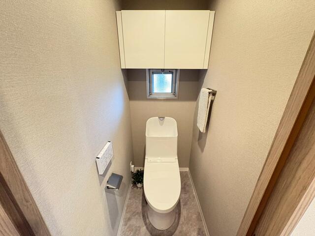 トイレ／小窓付きで自然光が入る明るいトイレ空間。上部には収納棚が設け／撮影日2026-03-14